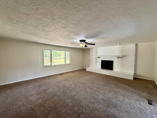 unfurnished living room featuring carpet floors, a brick fireplace, a textured ceiling, and ceiling fan