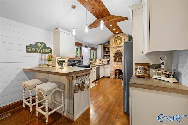 10161 US Highway 11, Springville, AL 35146 - kitchen with stainless steel appliances, a peninsula, a breakfast bar, wood finished floors, and decorative light fixtures