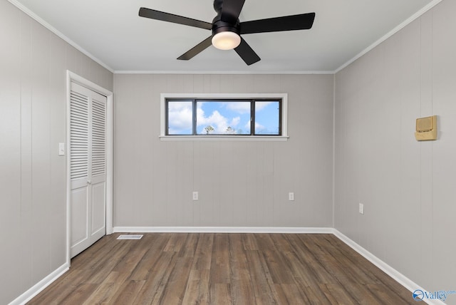 unfurnished bedroom with crown molding, a closet, ceiling fan, and dark hardwood / wood-style floors