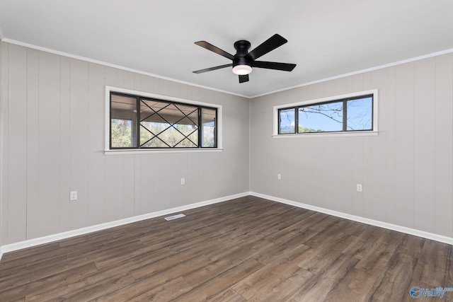 empty room with dark wood-type flooring and ornamental molding