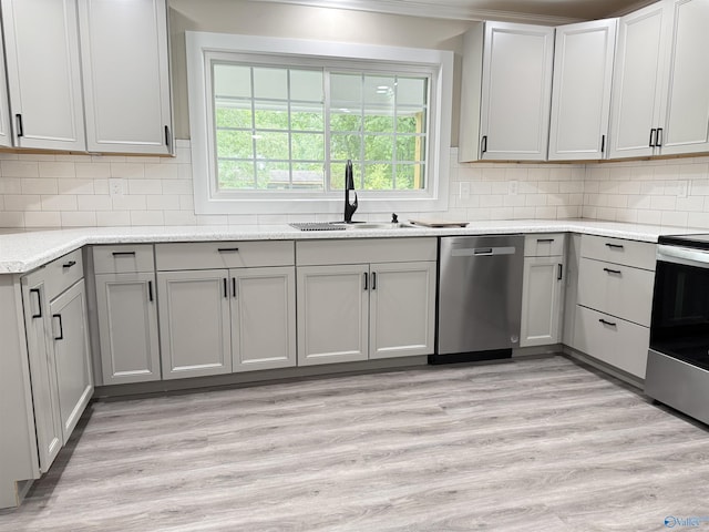 403 SW Arcadia St, Hartselle, AL 35640 - kitchen with appliances with stainless steel finishes, a sink, gray cabinets, tasteful backsplash, and light wood-style flooring