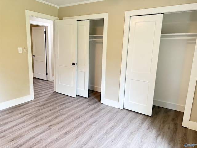 403 SW Arcadia St, Hartselle, AL 35640 - unfurnished bedroom with crown molding, wood finished floors, baseboards, and multiple closets