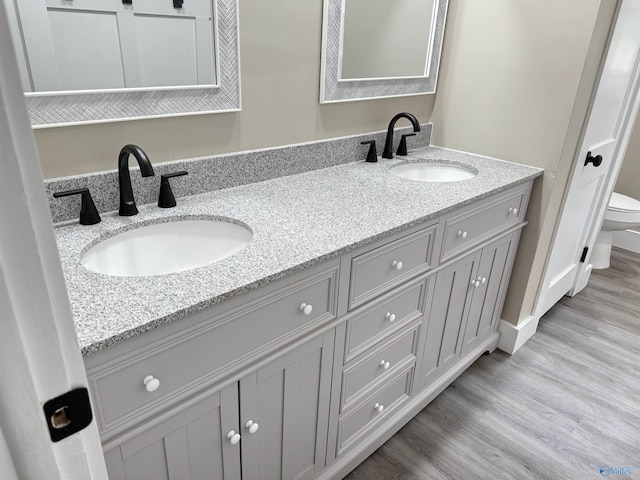 403 SW Arcadia St, Hartselle, AL 35640 - full bathroom with toilet, double vanity, and wood finished floors