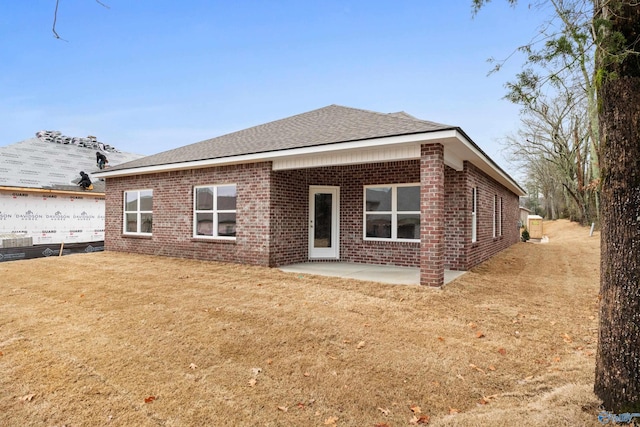 back of property featuring a patio area and a lawn