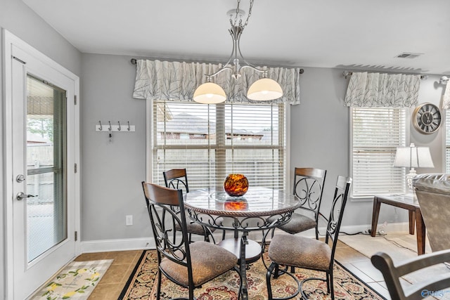 dining space featuring an inviting chandelier, tile patterned floors, and plenty of natural light