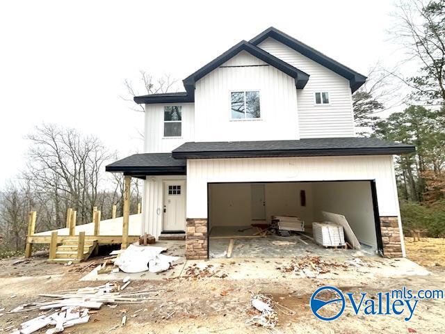 view of front of house with a garage, stone siding, and board and batten siding