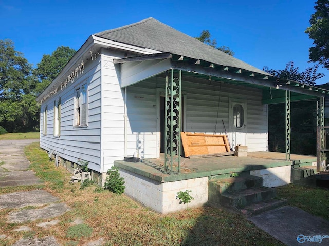 view of side of home featuring covered porch