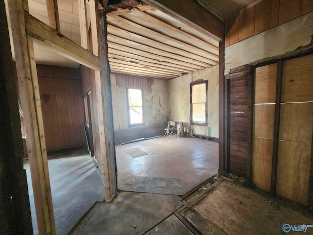 miscellaneous room with wood walls and concrete floors