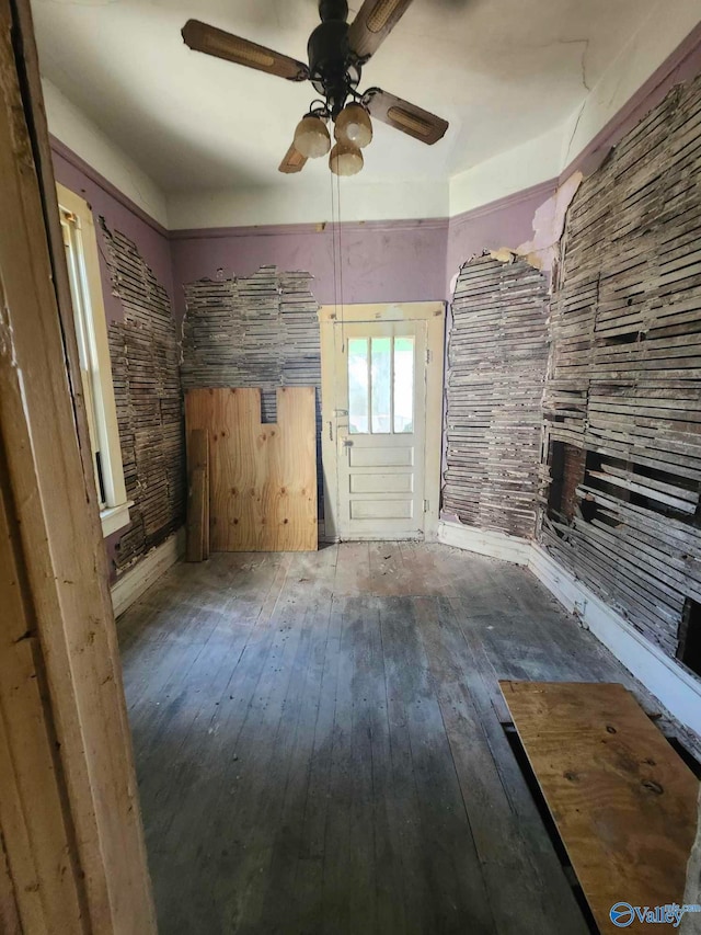 unfurnished living room with wood-type flooring and ceiling fan