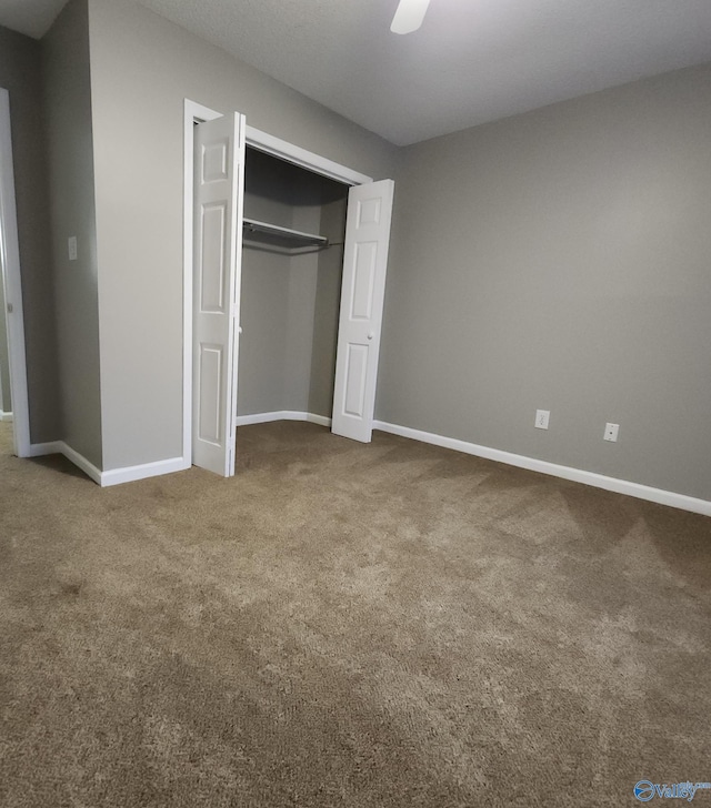 unfurnished bedroom with ceiling fan, a closet, and carpet floors