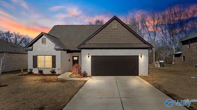 view of front of home with a garage and a lawn