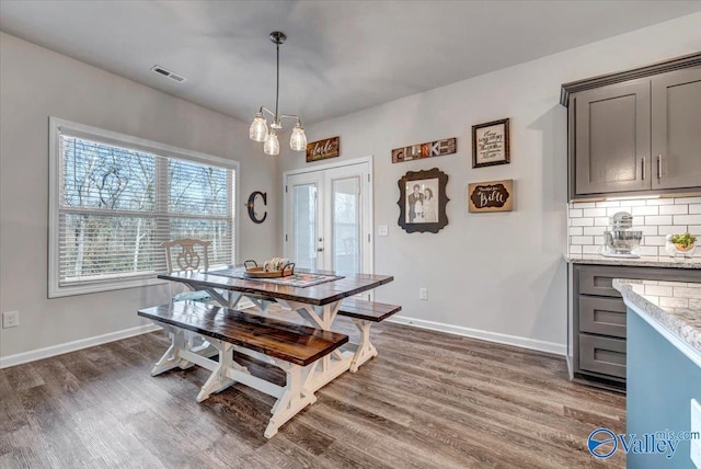 dining area with dark wood-type flooring and french doors