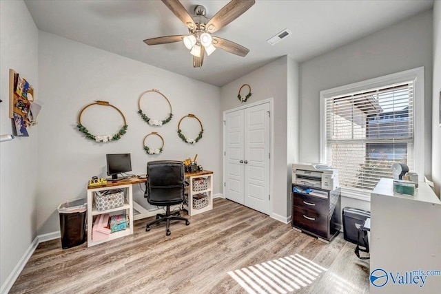 home office with ceiling fan and light hardwood / wood-style flooring