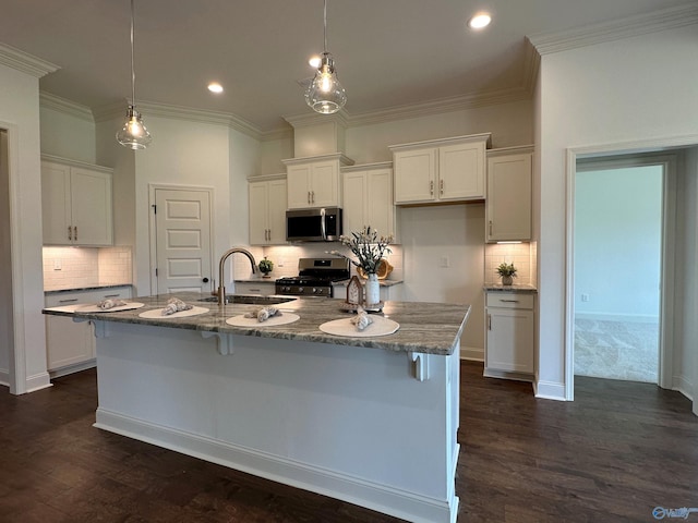 kitchen with stainless steel appliances, sink, a center island with sink, and white cabinets