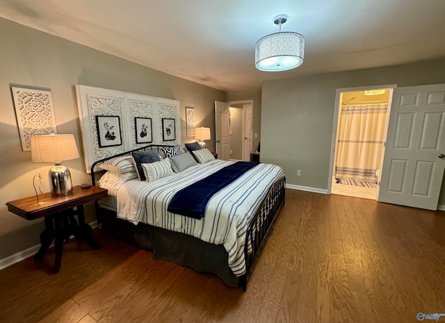 bedroom featuring connected bathroom and dark wood-type flooring