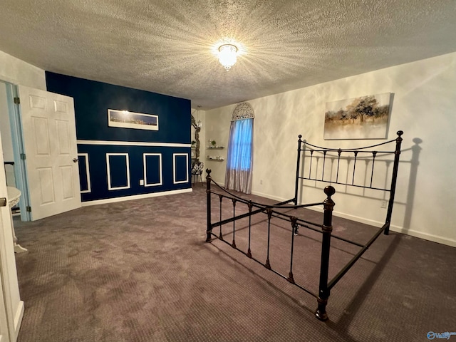 bedroom with dark carpet and a textured ceiling