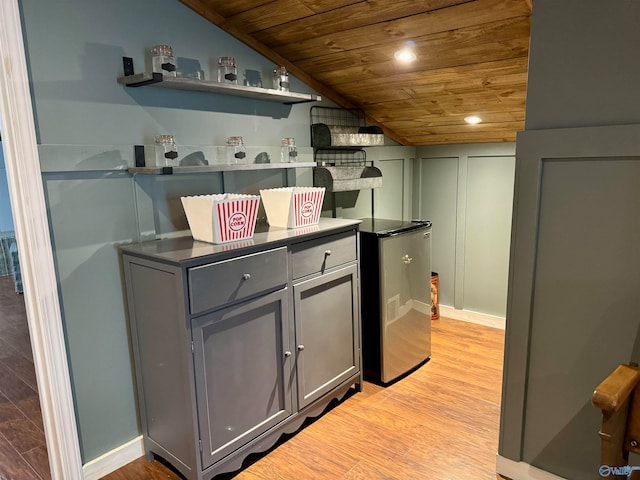 kitchen with light wood-type flooring, lofted ceiling, wooden ceiling, and stainless steel fridge