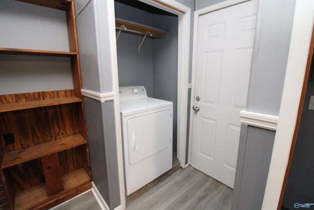 clothes washing area with light hardwood / wood-style flooring and washer / dryer