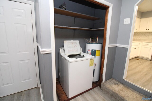 laundry area featuring light wood-type flooring, washer / dryer, and water heater