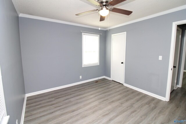 unfurnished room with ceiling fan, ornamental molding, and wood-type flooring