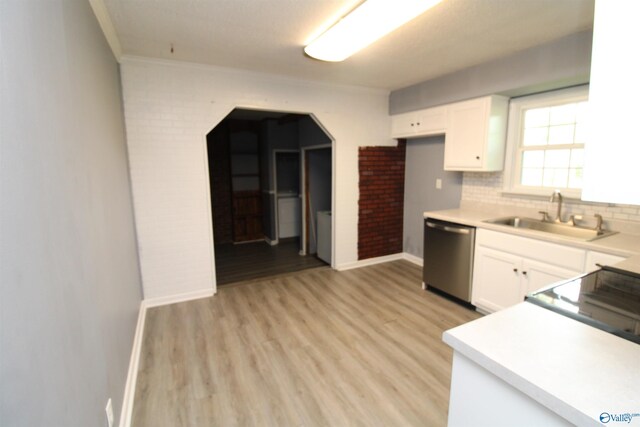 kitchen with light hardwood / wood-style floors, stainless steel dishwasher, sink, and white cabinets