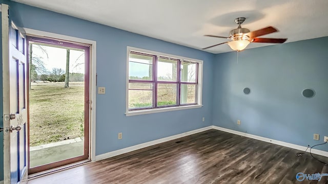 unfurnished room with dark wood-style floors, baseboards, and a ceiling fan