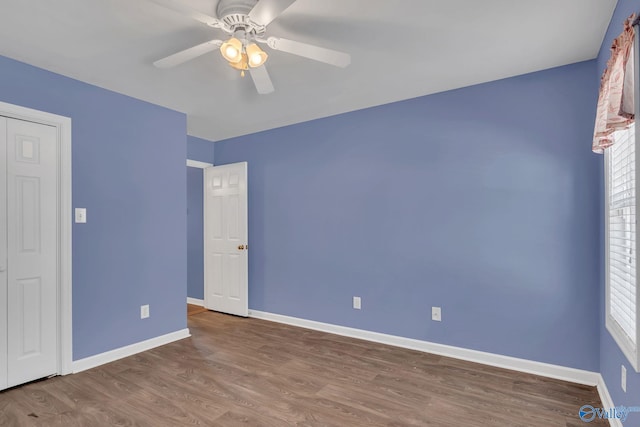 unfurnished bedroom featuring ceiling fan, wood finished floors, and baseboards