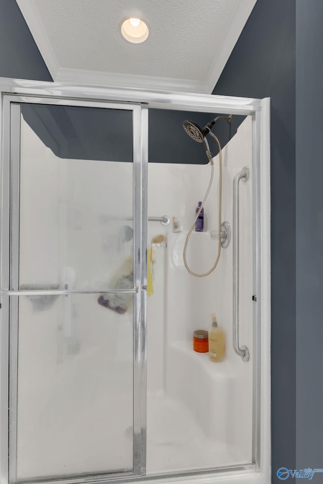 bathroom featuring a stall shower, ornamental molding, and a textured ceiling