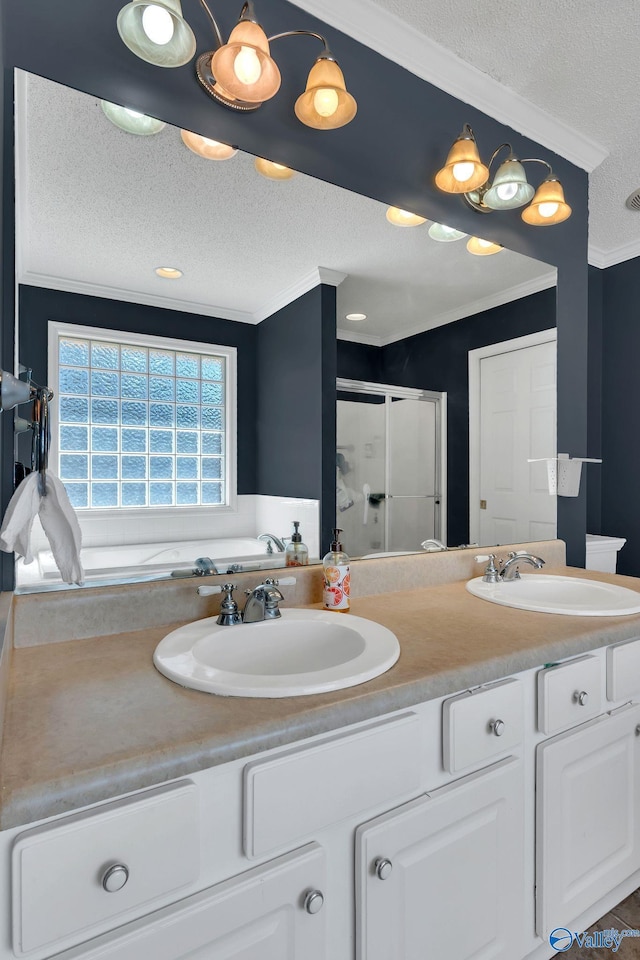 full bath with a stall shower, crown molding, a textured ceiling, and a sink