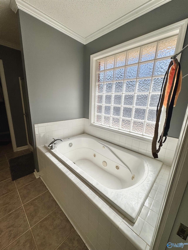 bathroom with a textured ceiling, ornamental molding, a whirlpool tub, and tile patterned floors