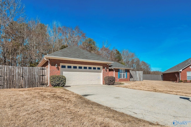 ranch-style home featuring a garage, driveway, brick siding, and fence