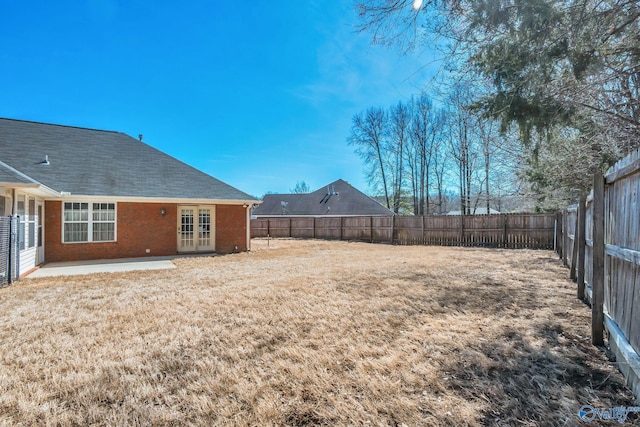 view of yard with french doors and a fenced backyard