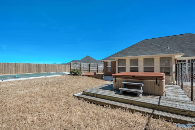 view of yard featuring fence and a hot tub