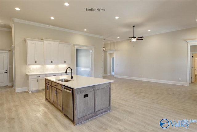 kitchen featuring dishwasher, an island with sink, sink, white cabinets, and light wood-type flooring