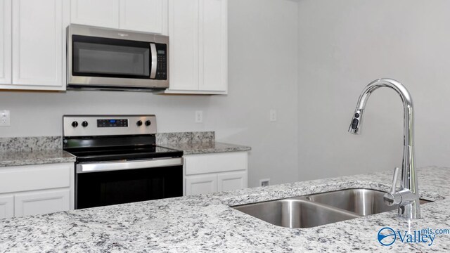 kitchen featuring white cabinets, stainless steel appliances, and a sink