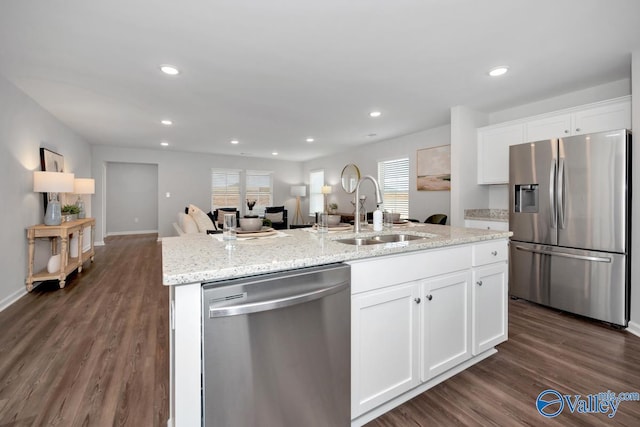 kitchen featuring appliances with stainless steel finishes, sink, a center island with sink, and white cabinets