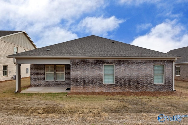 rear view of property featuring a lawn and a patio