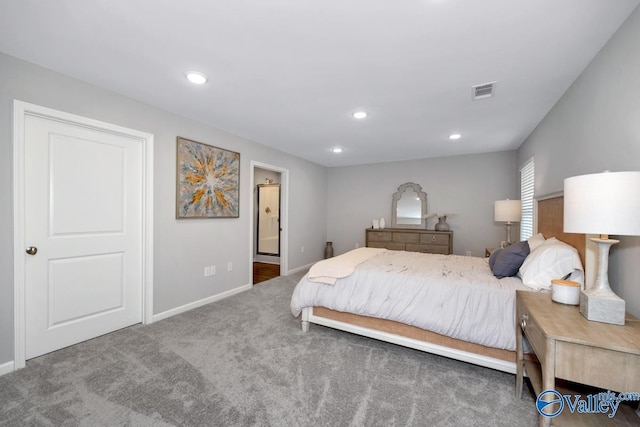 bedroom featuring ensuite bathroom and dark colored carpet