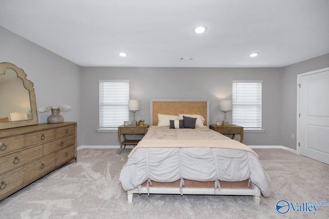 bedroom with light carpet and multiple windows