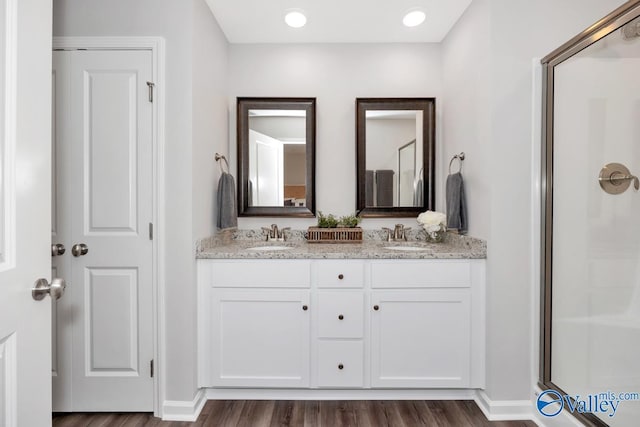 bathroom with vanity, a shower with shower door, and hardwood / wood-style floors