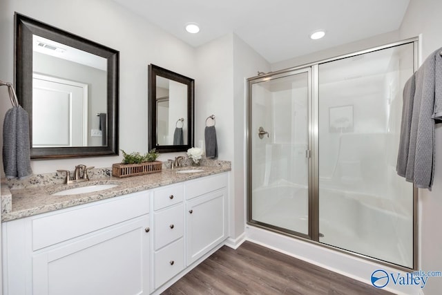 bathroom featuring hardwood / wood-style flooring, vanity, and walk in shower