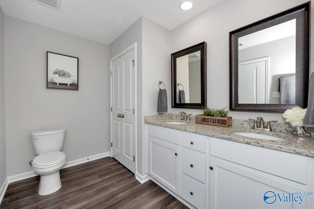 bathroom featuring wood-type flooring, vanity, and toilet