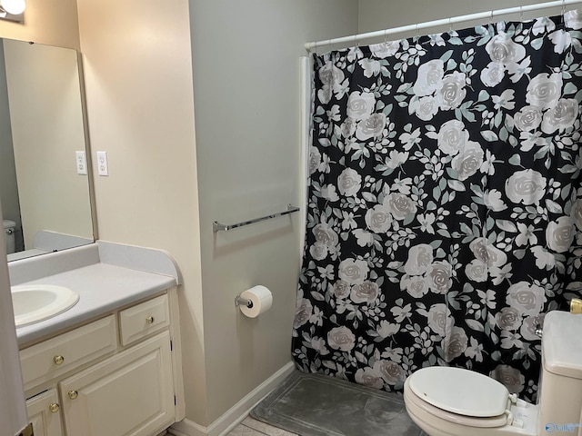 bathroom with toilet, baseboards, a shower with shower curtain, and vanity