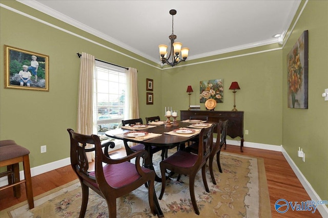 dining area featuring baseboards, light wood-style flooring, an inviting chandelier, and crown molding
