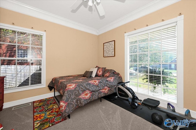 bedroom featuring ceiling fan, crown molding, visible vents, carpet, and baseboards