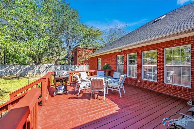 deck with a fenced backyard and outdoor dining area