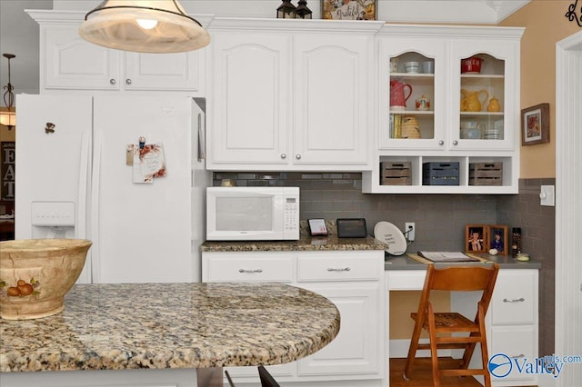 kitchen with glass insert cabinets, stone countertops, white cabinetry, and white appliances