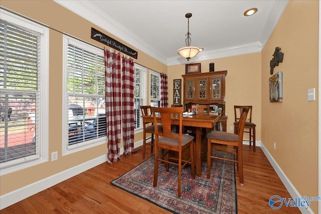 dining space featuring ornamental molding, wood finished floors, and baseboards