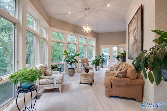 sunroom / solarium with a chandelier and french doors