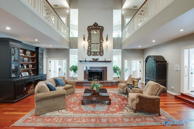 living room with wood-type flooring and a towering ceiling